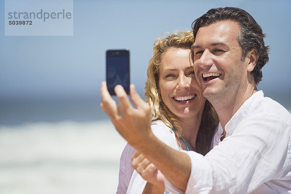 Paar fotografiert sich selbst mit einem Mobiltelefon