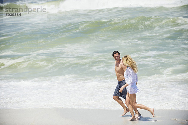 Seitenprofil eines am Strand laufenden Paares
