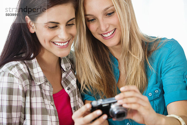 Weibliche Freunde  die ihr Bild in einer Kamera betrachten