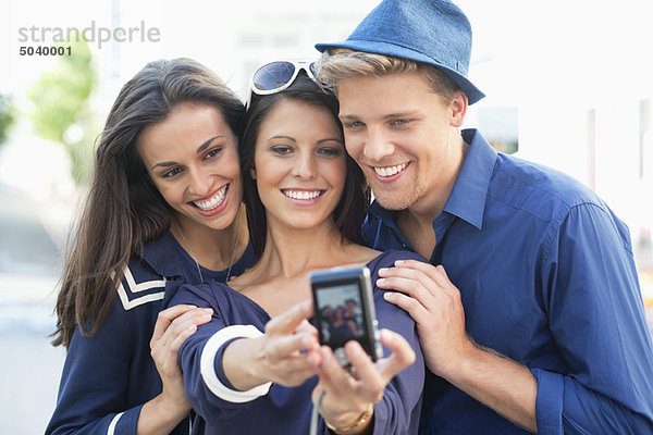 Drei junge Leute fotografieren sich selbst
