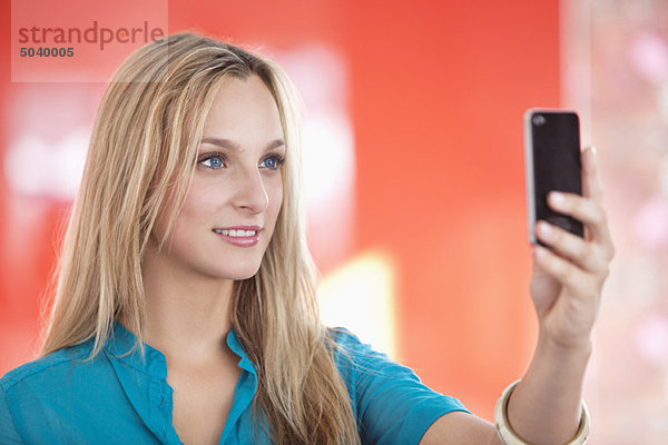 Junge Frau beim Fotografieren mit dem Handy