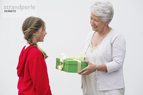 Seniorin schenkt ihrer Enkelin ein Geschenk
