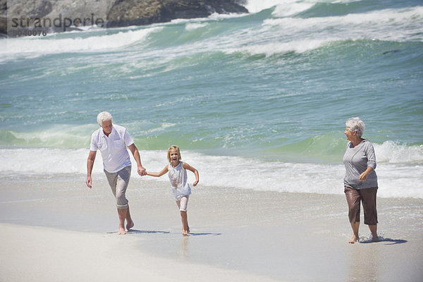 Seniorenpaar mit ihrer Enkelin am Strand