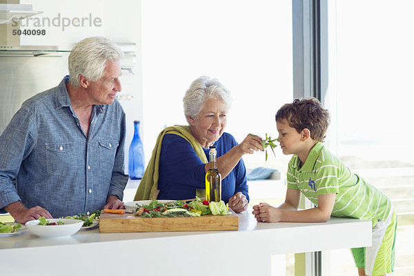 Seniorenpaar mit ihrem Enkel an der Küchentheke