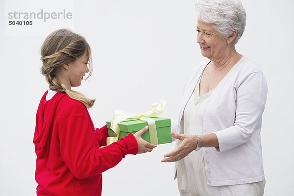 Seniorin schenkt ihrer Enkelin ein Geschenk