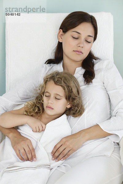 Junge Frau schläft mit kleinem Mädchen in Handtuch gewickelt