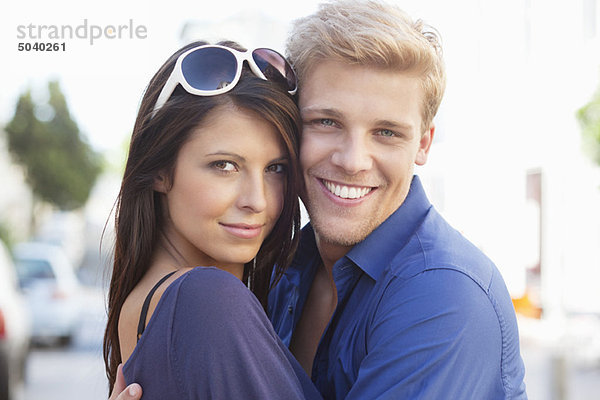 Porträt eines jungen Paares  das sich umarmt und lächelt