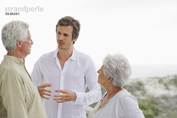 Ein erwachsener Mann  der mit seinen Eltern diskutiert.
