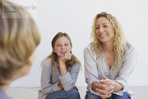 Mittlere erwachsene Frau im Gespräch mit ihrem Sohn und ihrer Tochter zu Hause