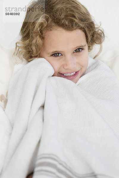 Süßes kleines Mädchen in ein weißes Handtuch gewickelt