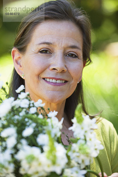 Porträt einer Frau mit einem Blumenstrauß im Freien