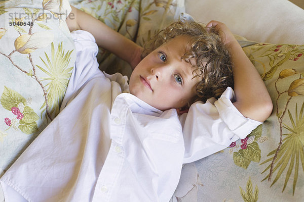 Porträt eines kleinen Jungen auf der Couch liegend