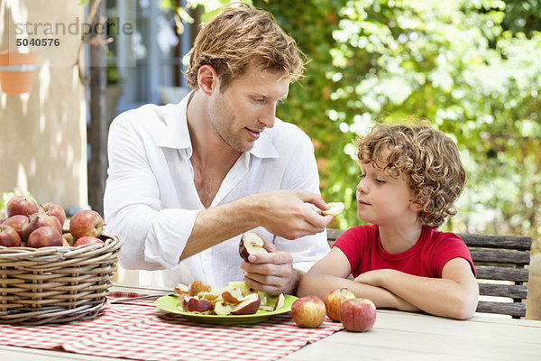 Vater füttert seinen Sohn mit Äpfeln