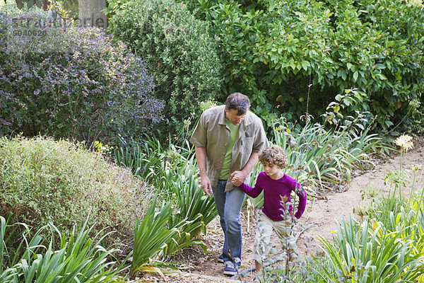 Vater und Sohn beim Spaziergang im Garten