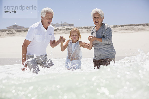 Mädchen genießt am Strand mit ihren Großeltern