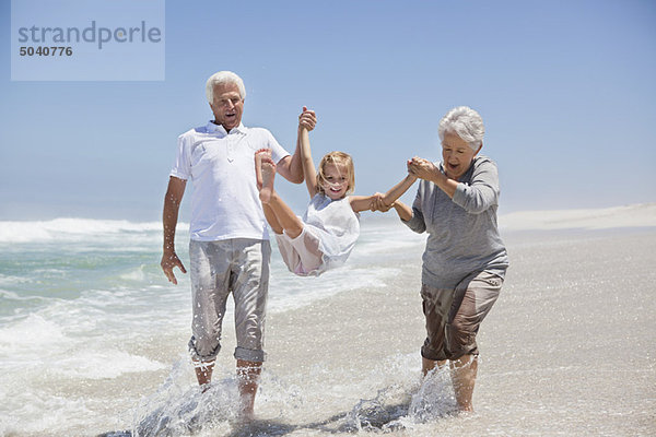 Mädchen genießt am Strand mit ihren Großeltern