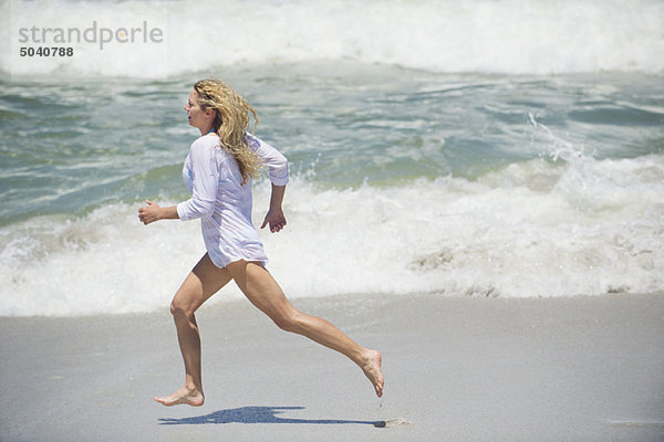 Seitenprofil einer schönen Frau  die am Strand läuft