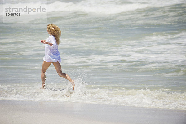Seitenprofil einer am Strand laufenden Frau