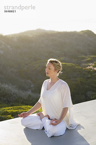 Mittlere erwachsene Frau beim Meditieren