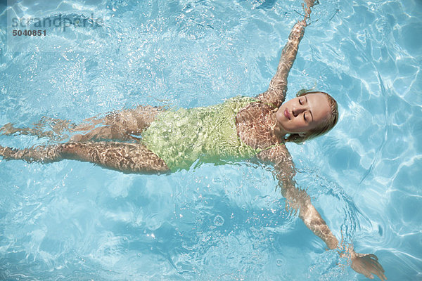 Schöne Frau  die in einem Schwimmbad schwimmt.