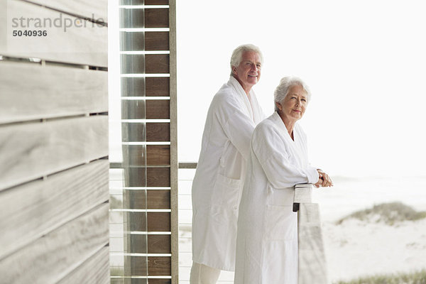 Seniorenpaar auf dem Balkon stehend
