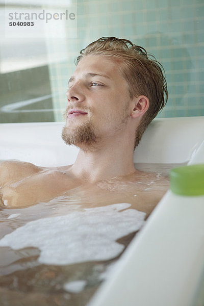 Mann entspannt in der Badewanne