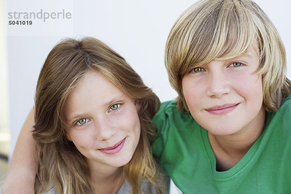 Porträt eines Teenagers  der mit seiner Schwester lächelt