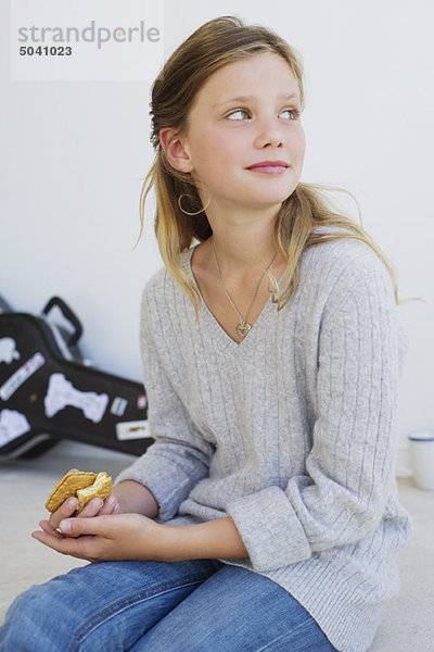 Seitenprofil eines schönen Mädchens  das Kekse isst