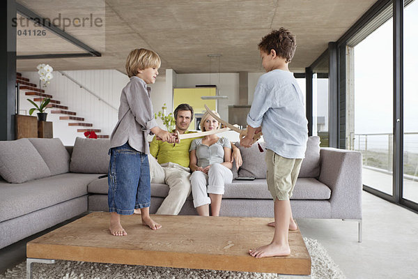 Jungen  die mit ihren Eltern auf einer Couch sitzen.