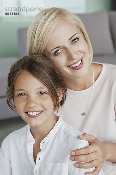 Porträt einer Frau  die mit ihrer Tochter lächelt
