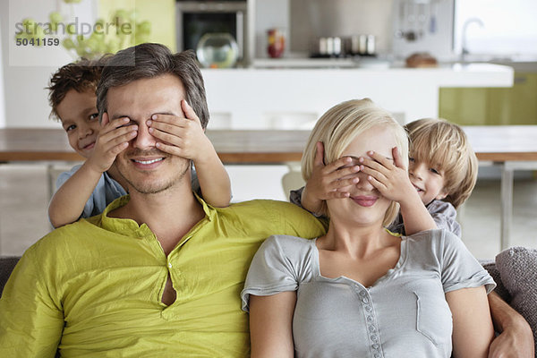 Kinder  die die Augen der Eltern bedecken