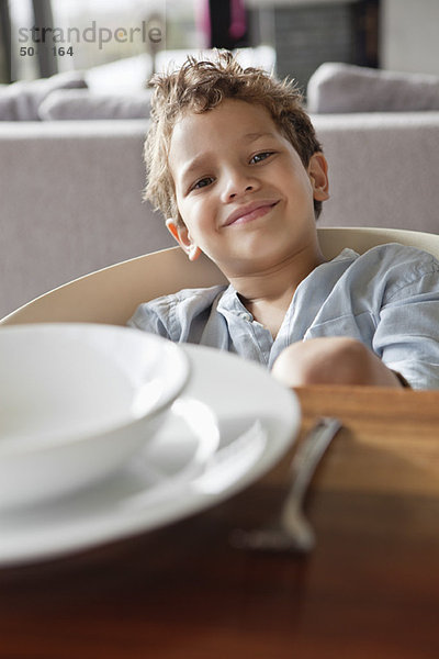Porträt eines Jungen  der am Esstisch sitzt