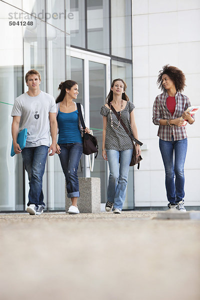 Universitätsstudenten  die auf dem Campus spazieren gehen