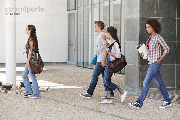 Universitätsstudenten  die auf dem Campus spazieren gehen
