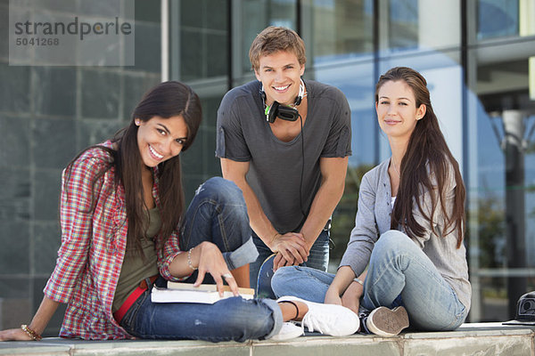 Porträt der lächelnden jungen Studenten auf dem Campus