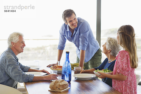 Mehrgenerationen-Familie beim Essen am Esstisch