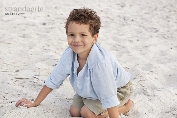 Porträt eines auf Sand spielenden Jungen