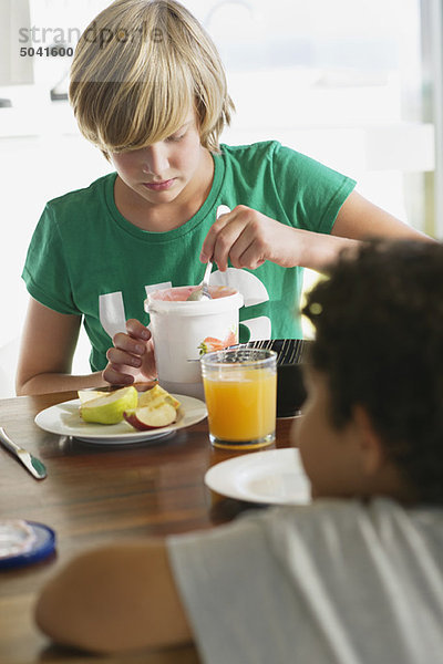Teenager-Junge beim Frühstück mit seinem Bruder  der vor ihm sitzt.