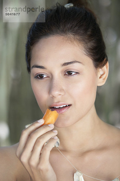 Junge Frau beim Essen einer Karotte