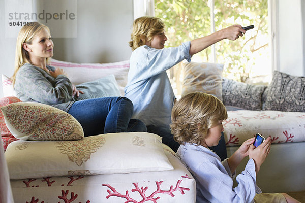 Kinder und Mutter mit elektronischen Geräten im Haus