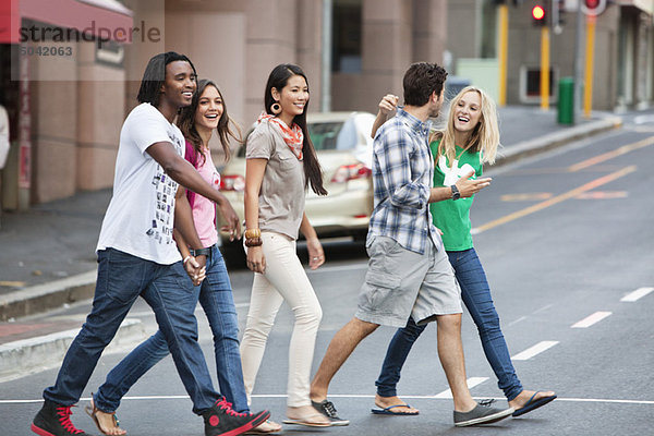 Lächelnde Freunde beim Überqueren der Straße