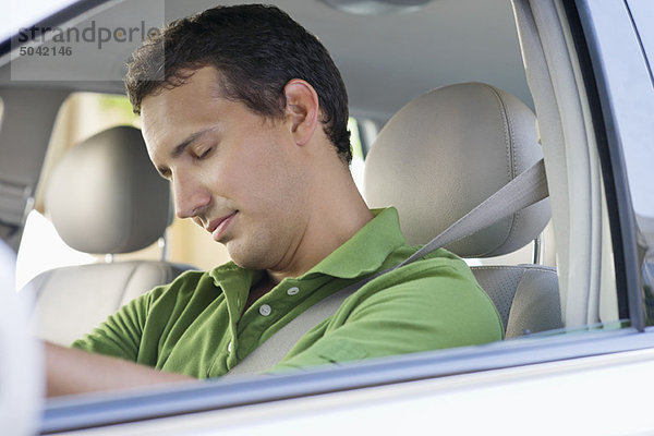 Mittlerer Erwachsener Mann  der beim Autofahren schläft