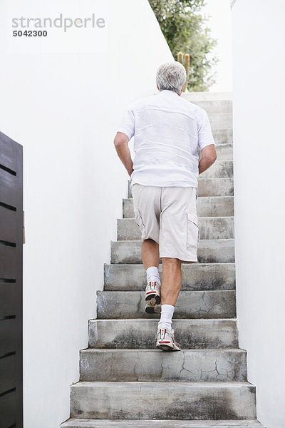Älterer Mann  der die Treppe hinaufgeht