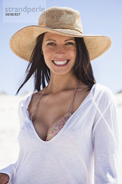 Porträt einer jungen Frau  die am Strand lächelt