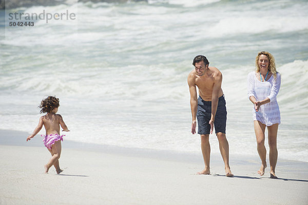 Glückliche Familie beim Spielen am Strand
