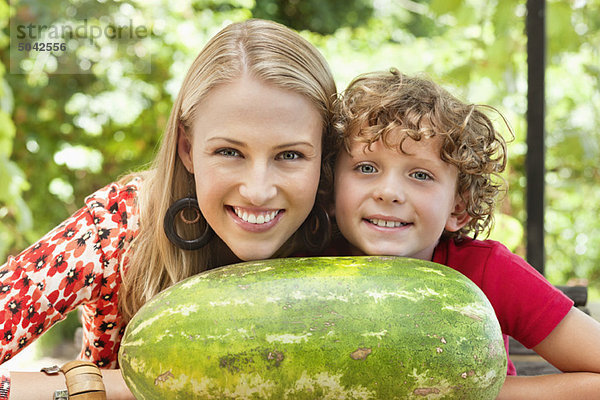 Mutter und Sohn auf Wassermelone gestützt
