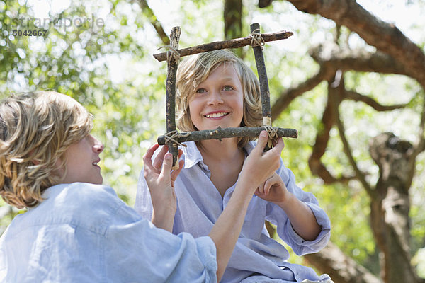 Kinder machen Treibholzrahmen im Freien