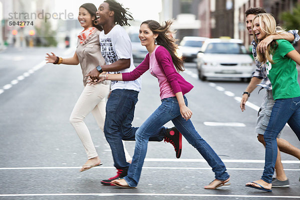 Lächelnde Freunde beim Überqueren der Straße