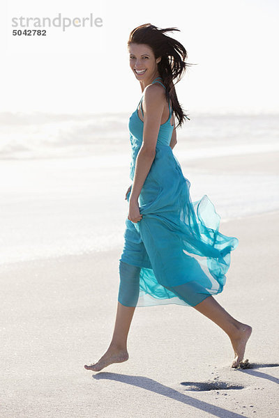 Porträt einer jungen Frau beim Spaziergang am Strand