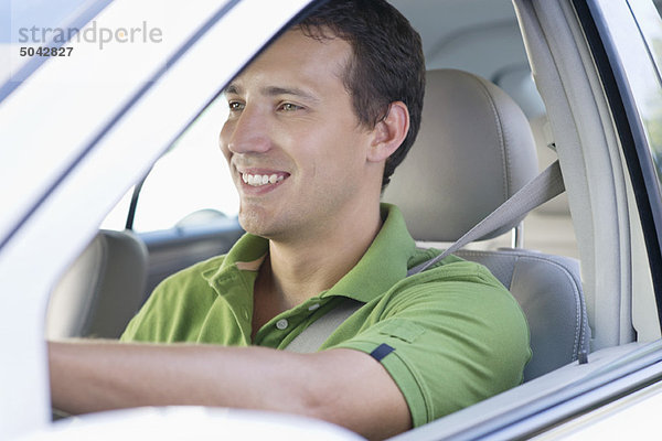 Lächelnder erwachsener Mann beim Autofahren